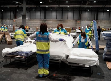 Health personnel prepare beds at the field hospital set up at the IFEMA Exhibition center in Madrid.