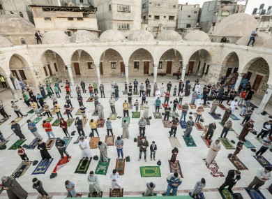 Muslims wearing face masks offer Eid al-Fitr prayer as they maintain a social distance in a mosque marking the end of the holy month of Ramadan