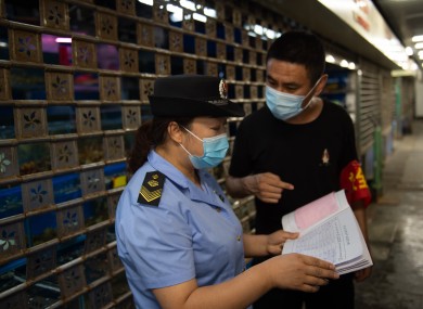 A supervisor examines the stock records of food and other products at the Yuegezhuang wholesale market in Beijing