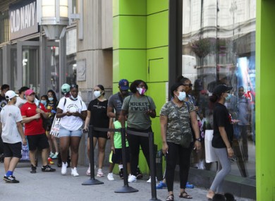 Customers wait in line to enter a store in New York.