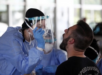 A Greek health worker takes swab samples from a tourist at the Promahonas border crossing with Bulgaria.