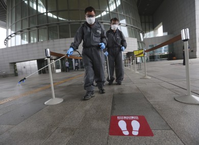 Workers spray disinfectant as a precaution against a new coronavirus at the National Museum of Korea in Seoul, South Korea