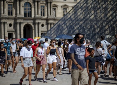 People walk past the Louvre Museum in Paris earlier this week.