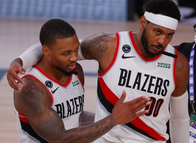 Carmelo Anthony and Damian Lillard of the Portland Trail Blazers celebrate a win against the Philadelphia 76ers.