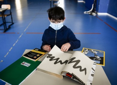 A child sits in a makeshift classroom inside a gym, as part of a pilot test to see how schools can reopen after Covid-19 in the region of Piedmont, Italy.