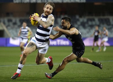Zach Tuohy of the Cats is tackled by Michael Gibbons of the Blues.