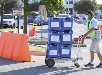 Travis County Elections officials collect boxes with mail-in ballots dropped off by voters in person as voting starts in Texas.