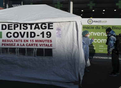 A laboratory medical staff worker speaks with a visitor at a Covid-19 test centre set up outside a pharmacy in Paris, France.