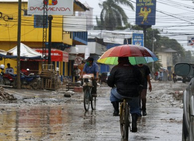 Locals move on street barely cleared from the debris of the last storm, before Hurricane Iota makes landfall in La Lima, Honduras