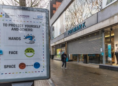 A man wearing a face mask walks past a closed Primark shop in Croydon in England yesterday.