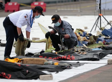 Investigators of the National Transportation Safety Committee inspect parts of the aircraft’s debris recovered from the Java Sea.