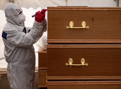 A volunteer marks coffins at Central Jamia Mosque Ghamkol Sharif in Birmingham, which operated as a temporary morgue for the Covid-19 pandemic in April 2020