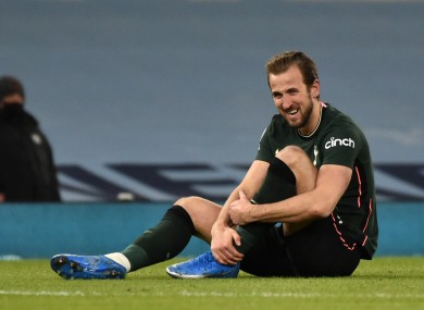 Harry Kane holding his ankle after being fouled.