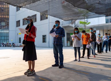 Residents wearing masks line up for a Covid-19 vaccination at the Jingcheng Hospital in Ruili