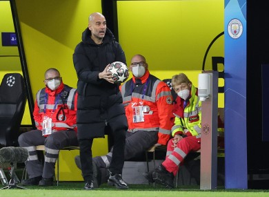 Man City manager Pep Guardiola holding a Champions League ball during his side's victory in Dortmund.