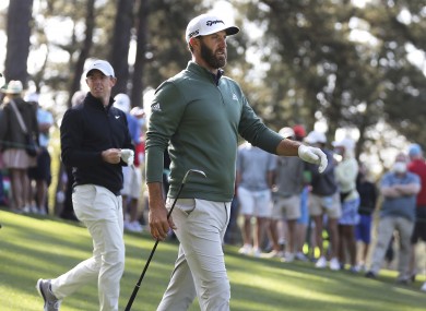 Defending Masters champion Dustin Johnson and Rory McIlroy walk the fourth fairway after teeing off during their practice round yesterday.