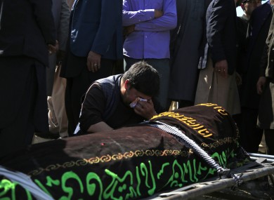 An Afghan man cries over the victim of deadly bombings at a cemetery west of Kabul on Sunday.