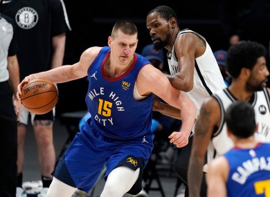 Nikola Jokic, left, drives on Kevin Durant: Durant's Nets were 125-119 winners.