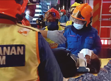 Rescuers transferring a passenger injured in a metro train collision in Kuala Lumpur, Malaysia today.