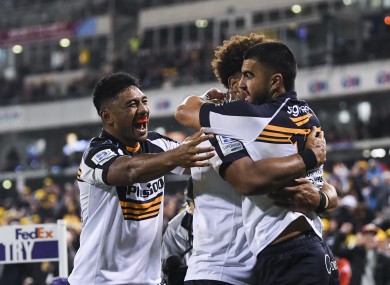 Tom Wright of the Brumbies celebrates with team-mates after scoring a try against the Force.
