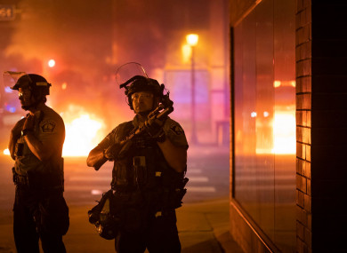 Police stand guard after protesters start fires after a vigil was held for Winston Boogie Smith Jr.
