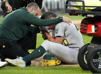 Chris Bassitt receiving treatment after being hit with the ball.