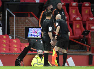 Referee Anthony Taylor consults with the VAR TV monitor at Old Trafford.