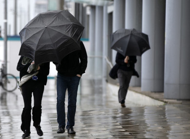 File image of people with umbrellas during rain in Dublin.