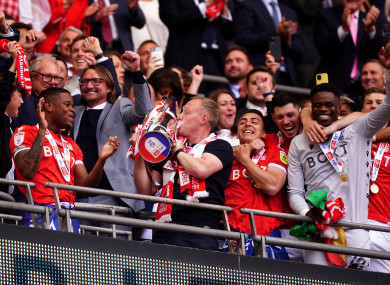 Nottingham Forest manager Steve Cooper (centre) kisses the trophy as he celebrates winning promotion to the Premier League.