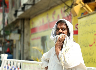 A man covers his head with a piece of cloth during a heatwave in Rawalpindi, Pakistan.