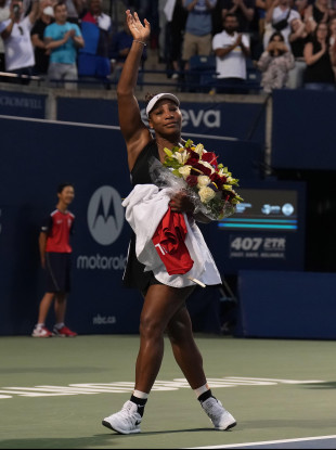 Serena Williams leaves the court carrying flowers and waving to fans after her defeat against Belinda Bencic.